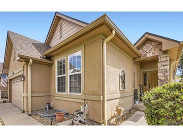 Charming home exterior with stucco siding, stone accents, and a welcoming entrance at 6694 S Rome St, Aurora, CO 80016