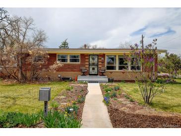 Charming brick home with a manicured front yard and inviting walkway at 345 Central Ave, Brighton, CO 80601