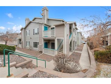 A beautiful shot of the outside of the home featuring two stories and blue doors on both levels at 8406 Pebble Creek Way # 202, Highlands Ranch, CO 80126