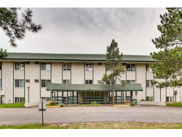 Exterior shot of apartment building with green trim, white exterior, and covered entry at 8826 E Florida Ave # 103, Denver, CO 80247