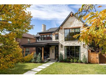 Stunning stone exterior with modern black trim, a covered porch and lush landscaping creates curb appeal at 1641 S Corona St, Denver, CO 80210