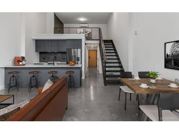 Open-concept living space with a kitchen bar, dining area, and living room at 1601 Park Ave # 112, Denver, CO 80218