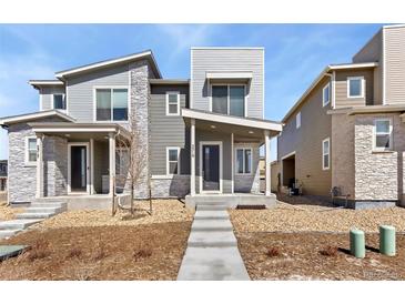 Contemporary home with neutral siding, stone accents and a well-manicured gravel front yard with inviting concrete pathway at 5319 Warrior St, Frederick, CO 80504