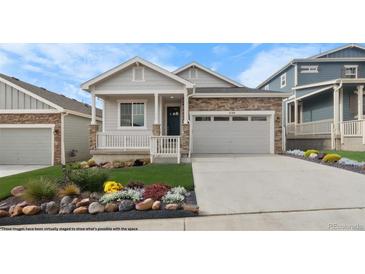 Charming single-Gathering home features stone accents, covered porch, well manicured lawn, and attached two car garage at 2149 Peralta Loop, Castle Rock, CO 80104