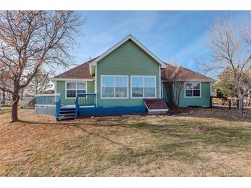 Charming home exterior showcasing a spacious backyard and a lovely wooden deck area at 4270 Defoe St, Strasburg, CO 80136