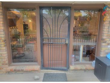 Inviting front entrance featuring a secure metal screen door and large windows bringing natural light at 2190 S Holly St # 213, Denver, CO 80222