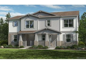 Charming townhome with stone accents, a covered porch, and beautiful landscaping at 5761 N Lisbon St, Aurora, CO 80019