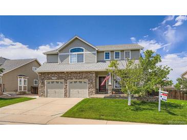 Charming two-story home featuring a stone facade, manicured lawn, and a two-car garage at 1793 E 164Th Pl, Thornton, CO 80602