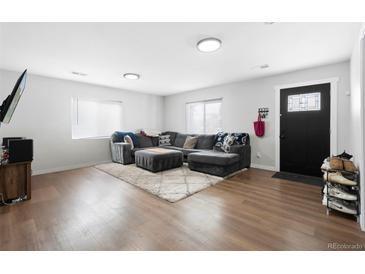 Bright living room features a comfortable gray sectional and wood flooring at 850 Grove St, Denver, CO 80204