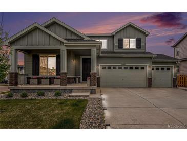 Two-story home boasts a three-car garage, a covered porch, and well-maintained landscaping at 12405 E 101St Dr, Commerce City, CO 80022