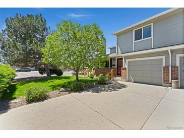 Charming two-story home with a well-maintained front yard and attached garage at 411 S Cody Ct, Lakewood, CO 80226