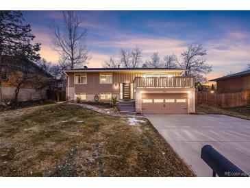 Ranch style home with attached garage and deck at 8340 E Princeton Ave, Denver, CO 80237