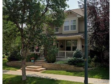 Charming two-story home with a welcoming front porch and well-manicured landscaping at 7742 E 8Th Pl, Denver, CO 80230