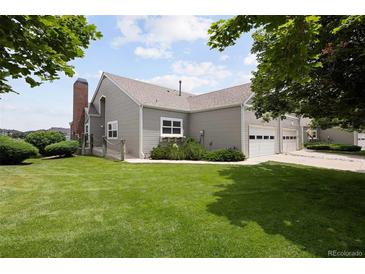 Lovely home exterior featuring a manicured lawn and an attached two car garage at 15555 E 40Th Ave # 36, Denver, CO 80239