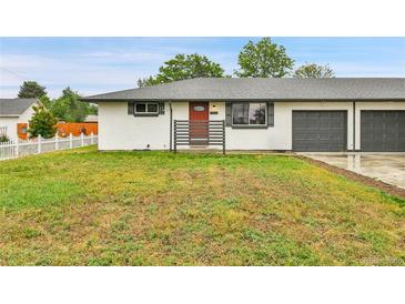 Charming exterior showcasing a well-manicured lawn, and a red front door on a well-maintained home at 4680 Independence St, Wheat Ridge, CO 80033