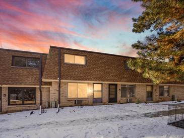 Townhouse with brick exterior, a brown roof, and mature trees, providing a cozy, homey feel at 12993 W 20Th Ave, Golden, CO 80401