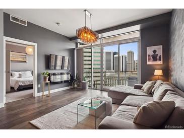 Contemporary living room boasts hardwood floors, city views, and an open doorway to the main bedroom at 2001 Lincoln St # 920, Denver, CO 80202