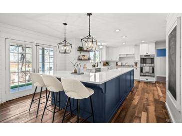 Bright, open kitchen with a large island, pendant lighting, modern appliances, and hardwood floors at 5795 S Pagosa Way, Centennial, CO 80015