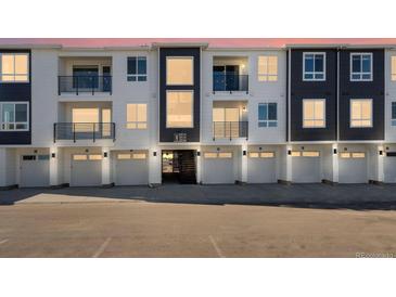 Modern townhome complex featuring individual garages and private balconies at 6153 N Ceylon St # 307, Denver, CO 80249