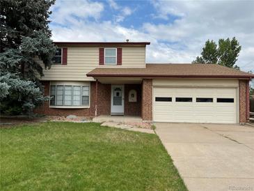 Charming two-story home featuring a brick and siding exterior, attached garage, and well-maintained front yard at 9062 Utica St, Westminster, CO 80031