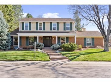 Charming two-story home with a well-manicured lawn, a brick facade, and inviting curb appeal at 3850 S Willow Way, Denver, CO 80237