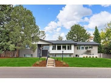 Charming single-story home with lush front lawn, mature trees, and gray exterior at 6088 S Lakeview St, Littleton, CO 80120