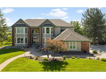 Charming two-story home featuring a beautifully landscaped front yard, inviting walkway, and an arched entryway at 50 Deerwood Dr, Littleton, CO 80127