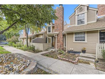 Charming townhome exterior with brick chimney, lovely landscaping, and inviting walkway at 14193 E Radcliff Cir, Aurora, CO 80015