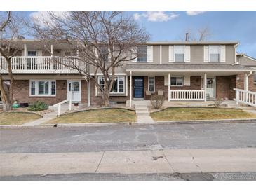 Charming townhome with a brick exterior, a covered front porch, and well-maintained landscaping at 7272 E Appleton Cir, Centennial, CO 80112