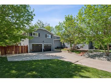 Lovely home with a large driveway, a two-car garage, and mature trees in the front yard at 2865 Newland St, Wheat Ridge, CO 80214