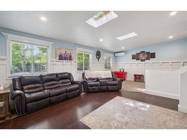 Bright living room featuring hardwood floors, two leather sofas and skylights at 2865 Newland St, Wheat Ridge, CO 80214