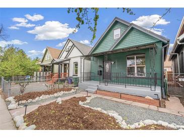 Charming green home with a cozy front porch and landscaped front yard at 3306 N Gilpin St, Denver, CO 80205