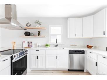 Bright kitchen featuring white cabinets, stainless steel appliances, floating shelves, and modern countertops at 1405 Eaton St, Lakewood, CO 80214