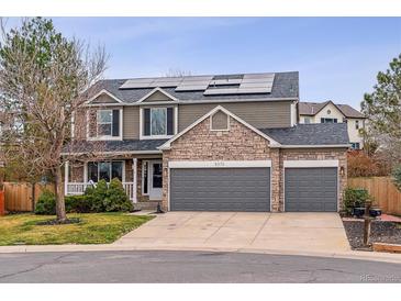 Inviting two-story home featuring a three-car garage, stone accents, solar panels, and well-maintained landscaping at 5370 S Flanders Way, Centennial, CO 80015