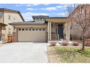 Tan two-story house with stone accents, two-car garage, and landscaping at 3280 Youngheart Way, Castle Rock, CO 80109