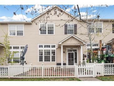 Charming two-story townhome with a well-kept front yard and a classic white picket fence at 1473 Red Cliff Way, Castle Rock, CO 80109