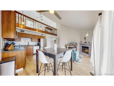 Open-concept living space featuring a modern kitchen, dining area, and cozy living room with a fireplace at 12368 W Nevada Pl # 303, Lakewood, CO 80228