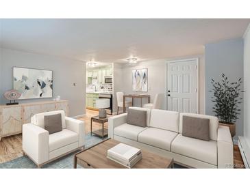 Bright living room featuring modern furnishings, including a white sofa and stylish decor, with a kitchen and dining space visible at 336 N Grant St # 412, Denver, CO 80203