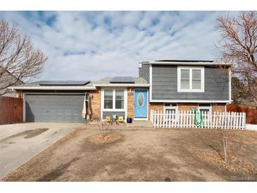 Two-story home with gray siding, attached garage, and a small front yard at 831 Centennial Dr, Bennett, CO 80102