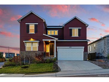Beautiful two-story home with a two car garage and a combination stone and siding exterior under a colorful sky at 4825 Basalt Ridge Cir, Castle Rock, CO 80108