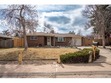 Charming red brick ranch-style home with manicured lawn and mature trees at 9390 W Alabama Dr, Lakewood, CO 80232