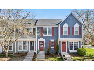 Charming townhouse featuring a blue exterior, red shutters, and a well-maintained front yard at 1055 Milo Cir # A, Lafayette, CO 80026
