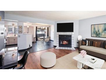 Open-concept living room with modern fireplace and hardwood floors at 6545 W 84Th Way # 124, Arvada, CO 80003