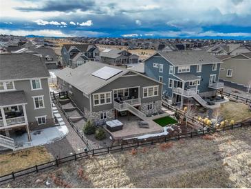 An aerial view of the backyard with a patio, hot tub, and artificial turf, enclosed by a charming black fence at 23049 E Narrowleaf Dr, Aurora, CO 80016