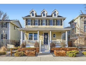 Charming home with a welcoming front porch, dormer windows, and manicured landscaping at 9113 E 36Th Ave, Denver, CO 80238