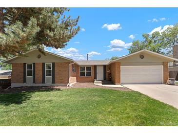 Charming brick home with mature trees, a well-maintained lawn, and an attached two-car garage at 2964 S Akron St, Denver, CO 80231