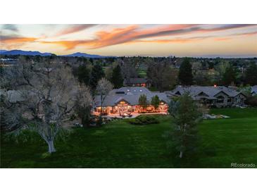 Expansive estate with manicured lawn and outdoor living spaces at twilight at 18 Club Ln, Littleton, CO 80123