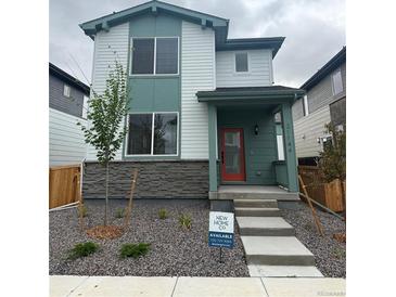 Charming two-story home with a red front door and a modern, landscaped front yard at 21144 E 63Rd Dr, Aurora, CO 80019