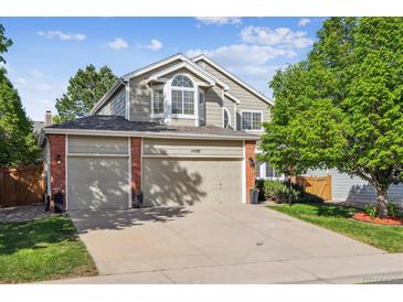 Inviting home with a brick-accented facade, two-car garage, and well-maintained lawn at 15597 E Dorado Ave, Centennial, CO 80015