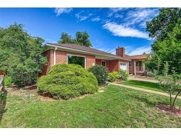 Charming brick home featuring a well-maintained lawn and mature landscaping at 1541 Poplar St, Denver, CO 80220